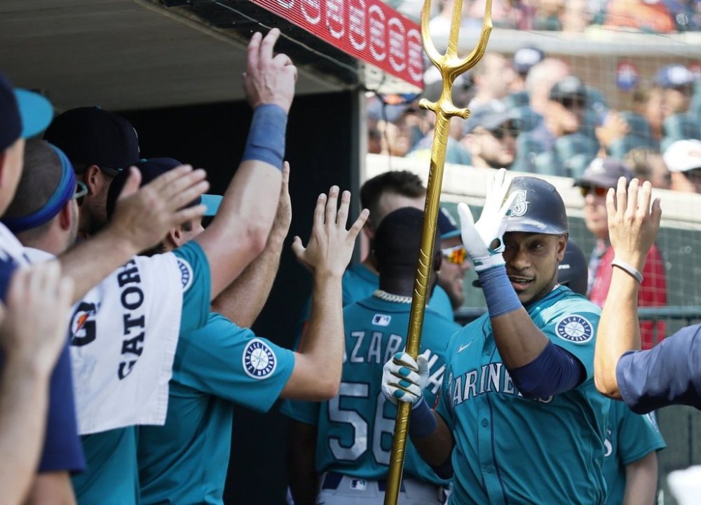 Seattle Mariners' Jorge Polanco celebrates in the dugout after hitting a solo home run to take a lead against the Detroit Tigers during the ninth inning of a baseball game, Sunday, July 13, 2025, in Detroit. (AP Photo/Duane Burleson)