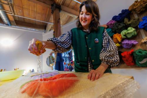 MIKE DEAL / FREE PRESS Christie squeezes a sponge full of water onto some wool while making Wall Flowers. Christie Peters of Margaret Jane Design in her studio. Christie Peters makes felted flowers and felted vases as well as wall hanging pieces. Reporter: AV Kitching 250625 - Wednesday, June 25, 2025. (Mike Deal / Free Press)
