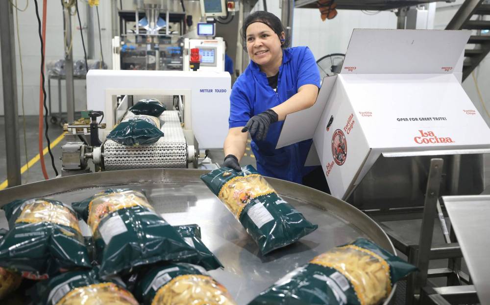 La Cocina Foods employee Larissa box up bags of freshly made tortilla chips. (Ruth Bonneville / Free Press)
