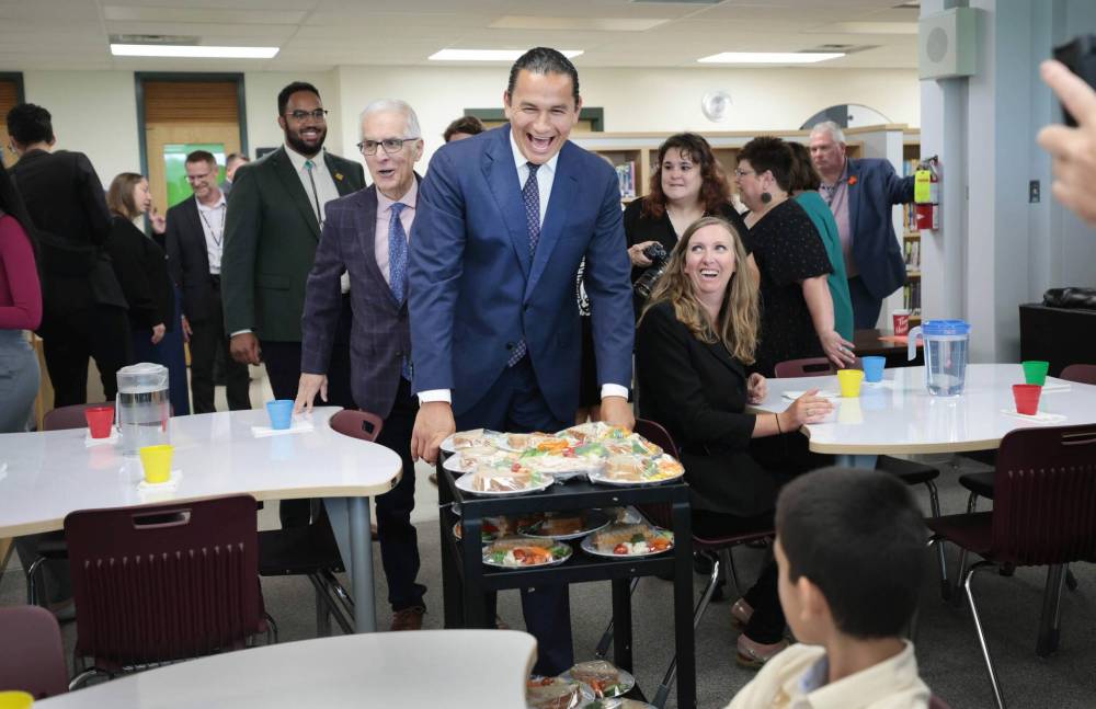 Ruth Bonneville / Free Press Manitoba
Premier Wab Kinew hands out lunch after a school nutrition news conference.