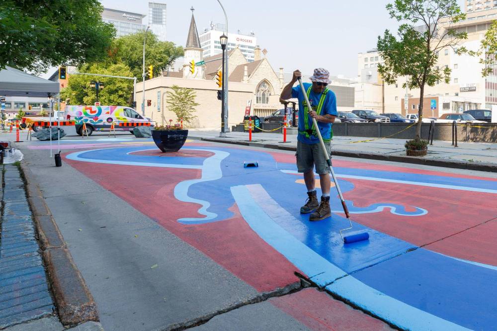 MIKE DEAL / FREE PRESS Artist, Mike Zastre (@iron_buddha), creating one of several murals along a four-block stretch of Graham between Carlton and Garry Street Tuesday morning. 250708 - Tuesday, July 08, 2025.