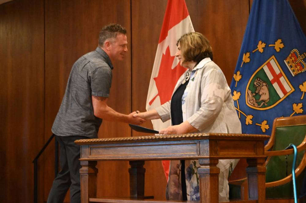 Christian Clavelle (left) receives the Rescue Commendation Award from Lt.-Gov. Anita Neville. (Matthew Frank / Free Press)