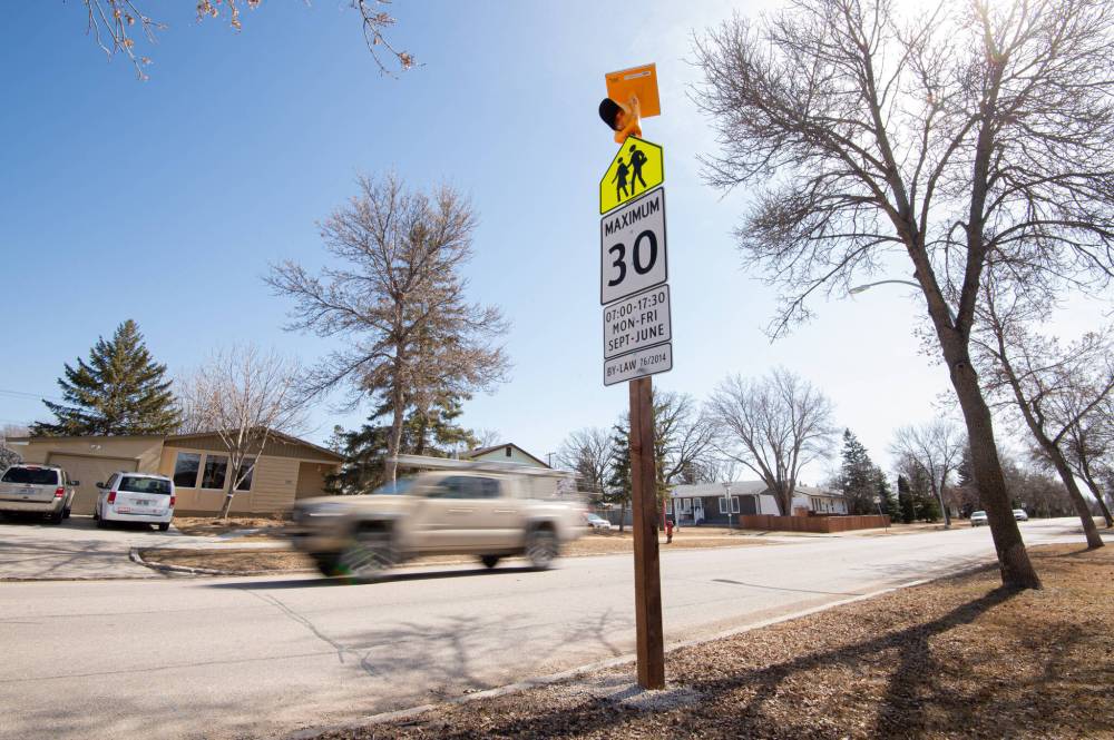MIKE SUDOMA / FREE PRESS FILES
A truck drives by a school zone speed limit sign adorned with a blinking amber light on Bedson Street.