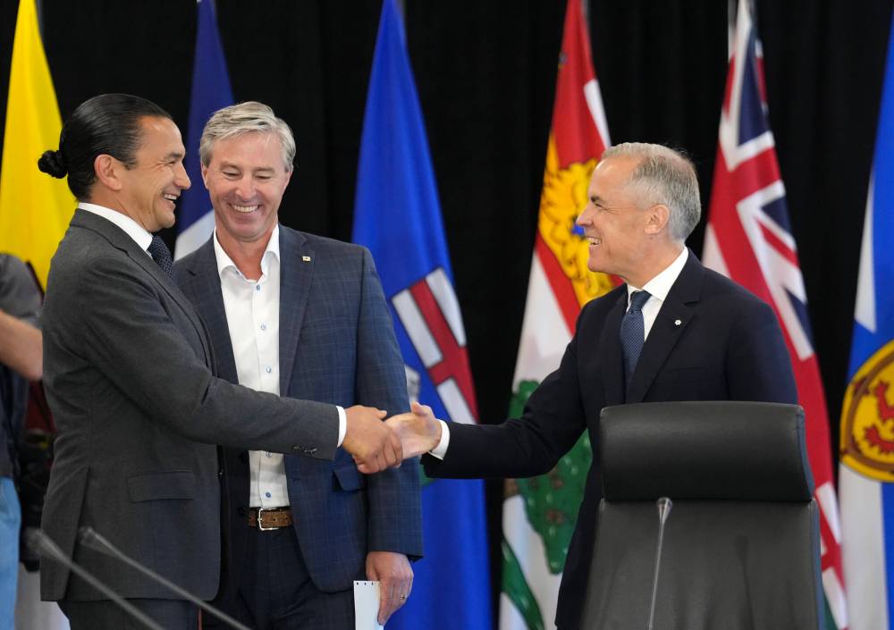 NATHAN DENETTE / THE CANADIAN PRESS
Prime Minister Mark Carney greets Manitoba Premier Wab Kinew as Nova Scotia Premier Tim Houston looks on, during the first ministers meeting in Huntsville, Ont., on Tuesday.
