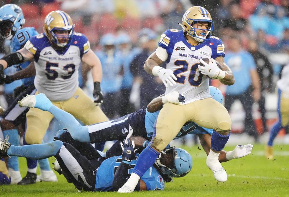 Nathan Denette / THE CANADIAN PRESS
Winnipeg Blue Bombers running back Brady Oliveira (20) tries to break through the Toronto Argonauts defence during first half CFL football action in Toronto on Saturday, July 26, 2025.