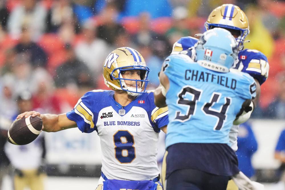 Nathan Denette / THE CANADIAN PRESS
Winnipeg Blue Bombers quarterback Zach Collaros (8) looks to pass as Toronto Argonauts defensive lineman Andrew Chatfield (94) pressures during first half CFL football action in Toronto on Saturday, July 26, 2025.