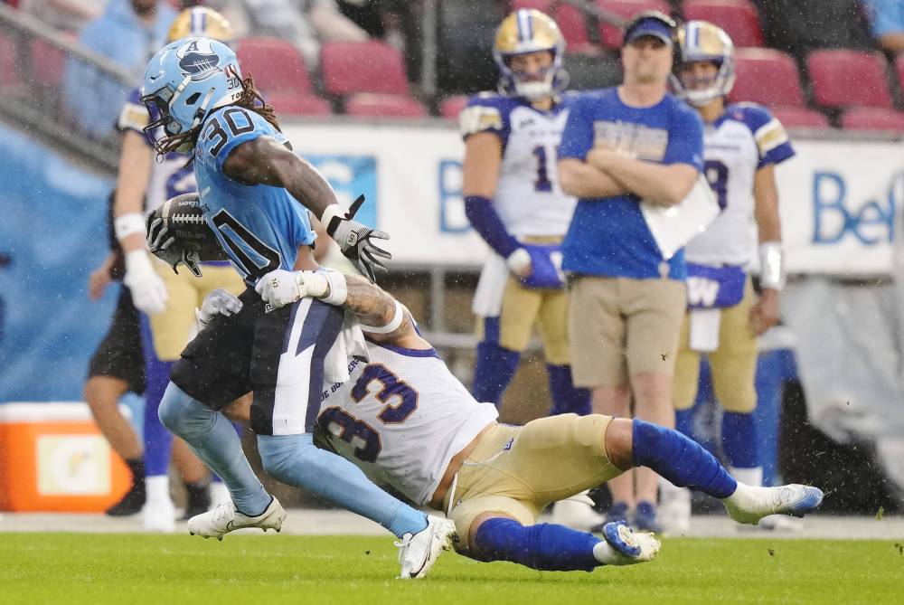 Nathan Denette / THE CANADIAN PRESS
Winnipeg Blue Bombers linebacker Tony Jones (33) tries to tackle Toronto Argonauts running back Khalan Laborn (30) during first half CFL football action in Toronto on Saturday, July 26, 2025.