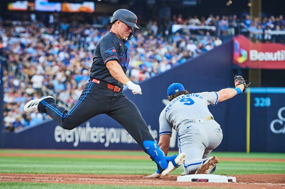 Toronto Blue Jays Outfielder Daulton Varsho (5) is out as Kansas City Royals first base Vinnie Pasquantino (9) makes a catch during fourth inning MLB baseball action in Toronto, Friday, Aug. 1, 2025. THE CANADIAN PRESS/Sammy Kogan