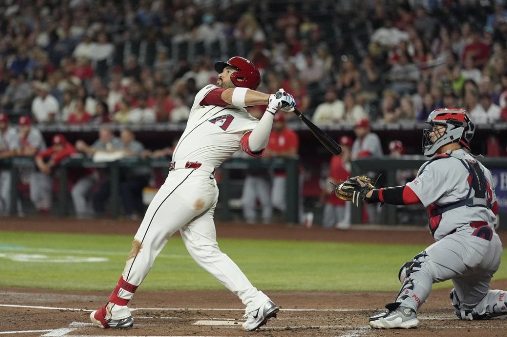 Arizona Diamondbacks' Eugenio Suárez, left, watches the flight of his three-run home run as St. Louis Cardinals catcher Yohel Pozo, right, looks on during the first inning of a baseball game Sunday, July 20, 2025, in Phoenix. (AP Photo/Ross D. Franklin)