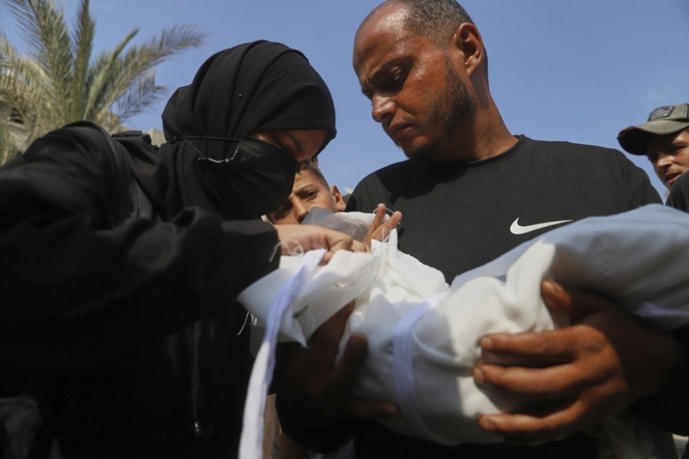 Ahmed Abu Halib and his wife Esraa Abu Halib, left, mourn over the body of their 5-month-old baby, Zainab, who died from malnutrition-related causes, according to the family, during her funeral outside the Nasser Hospital, in Khan Younis, Gaza Strip, Saturday, July 26, 2025. (AP Photo/Mariam Dagga)