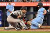 Toronto Blue Jays' Davis Schneider, right, scores a run ahead of a tag by New York Yankees catcher J.C. Escarra, left, in fifth inning MLB baseball game action in Toronto on Wednesday, July 23, 2025. THE CANADIAN PRESS/Jon Blacker
