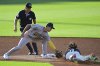 Athletics second base Max Muncy, left, tags out Cleveland Guardians' Jose Ramirez attempting to steal second base in the first inning of a baseball game, Friday, July 18, 2025, in Cleveland. (AP Photo/David Dermer)