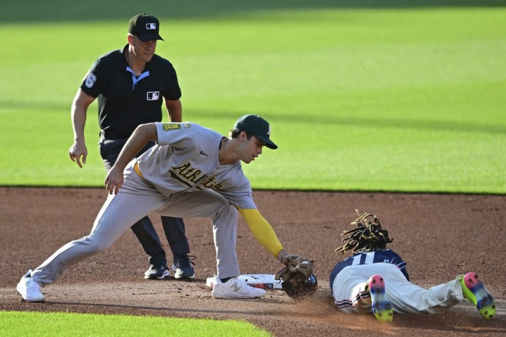 Athletics second base Max Muncy, left, tags out Cleveland Guardians' Jose Ramirez attempting to steal second base in the first inning of a baseball game, Friday, July 18, 2025, in Cleveland. (AP Photo/David Dermer)