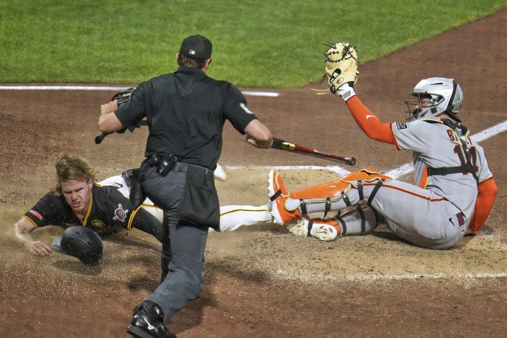 As umpire Ryan Addison, center, makes the call, Pittsburgh Pirates' Jack Suwinski, left, scores a walkoff winning run ahead of a tag by San Francisco Giants catcher Patrick Bailey, right, on a fielder's choice hit into by Isiah Kiner-Falefa off pitcher Randy Rodríguez during the ninth inning of a baseball game in Pittsburgh, Monday, Aug. 4, 2025. (AP Photo/Gene J. Puskar)