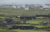 FILE - Northern Ireland's Rory McIlroy, in blue top and cap, squats down to look at his putt on the 6th green during the first round of the British Open Golf Championships at Royal Portrush in Northern Ireland, July 18, 2019. (AP Photo/Matt Dunham, File)