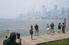 Tourists pose for a photo against city view of Toronto on Monday July 14, 2025. The Air Quality Health Index rating for Toronto was over 10, or 