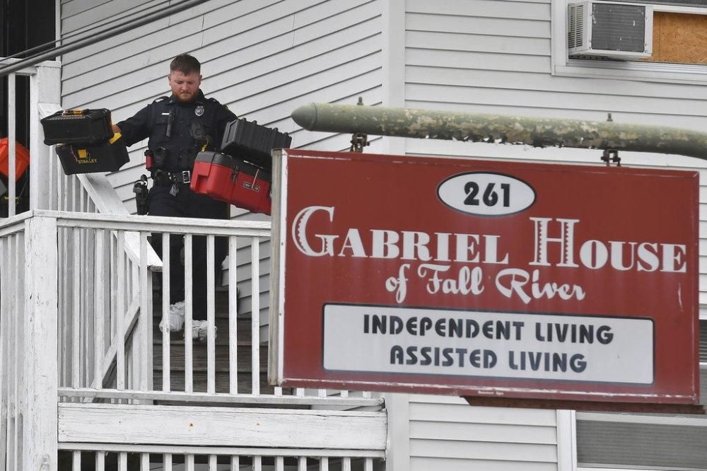 A law enforcement official removes boxes containing patient medications from the Gabriel House assisted living facility following a fire that resulted in multiple fatalities, in Fall River, Mass., Monday, July 14, 2025. (AP Photo/Steven Senne)