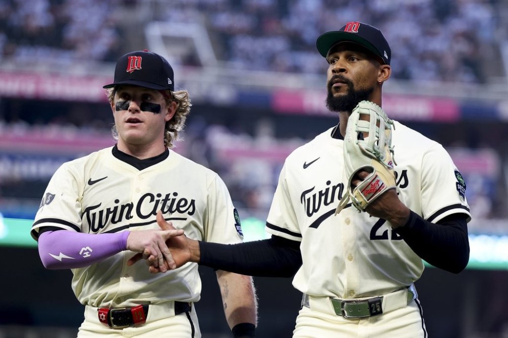 Minnesota Twins left fielder Harrison Bader, left, and center fielder Byron Buxton, right, shake hands after the sixth inning of a baseball game against the Washington Nationals, Friday, July 25, 2025, in Minneapolis. (AP Photo/Ellen Schmidt)