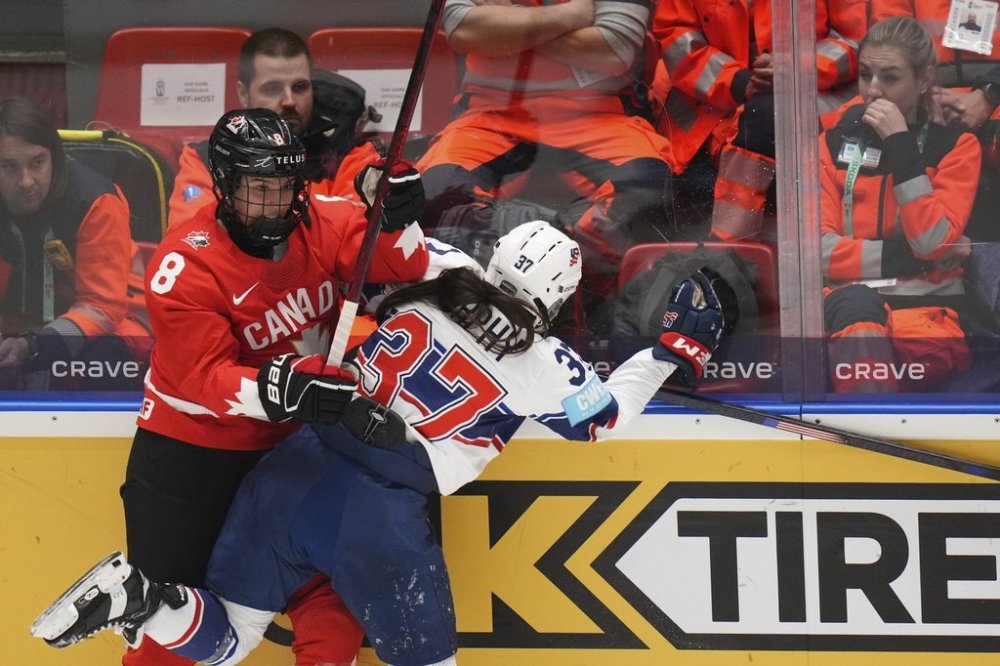 Chloe Primerano of Canada, left, challenges United States' Abbey Murphy during the group A match between United States and Canada at the Women's Ice Hockey Championships in Ceske Budejovice, Czech Republic, Sunday, April 13, 2025. (AP Photo/Petr David Josek)