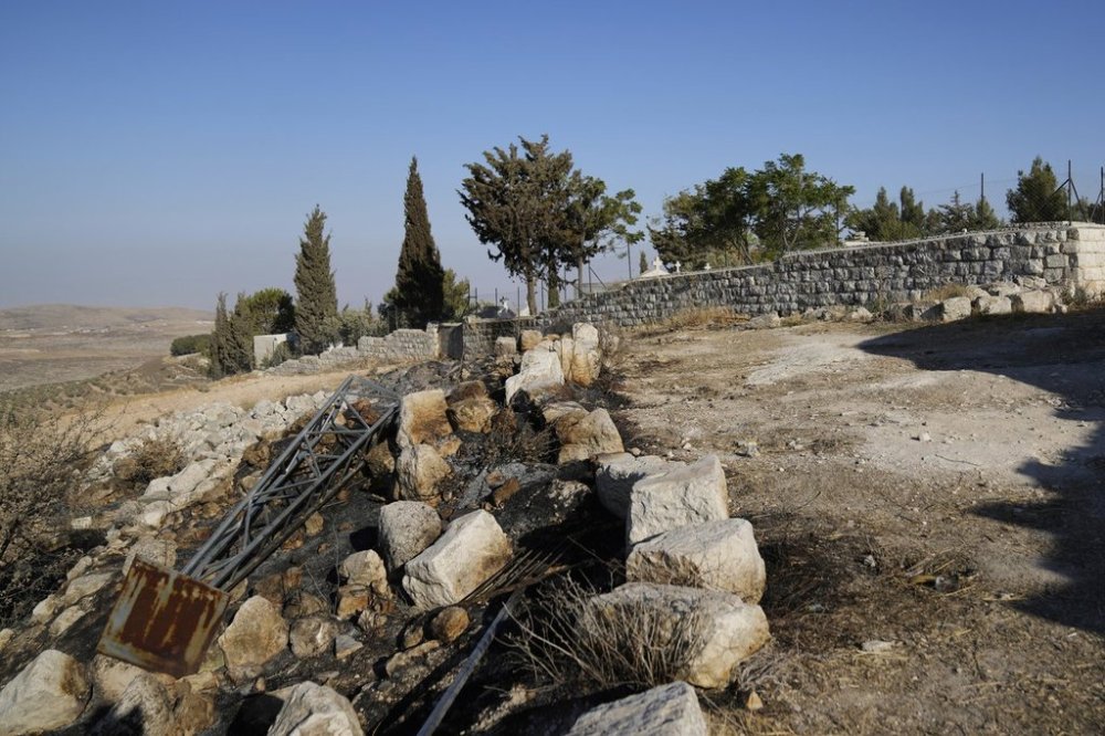 Char marks Palestinians say are from an attack by Israeli settlers are visible in the cemetery nearby the Saint George Greek Orthodox Church in the West Bank village of Taybeh, Monday, July 14, 2025. (AP Photo/Nasser Nasser)