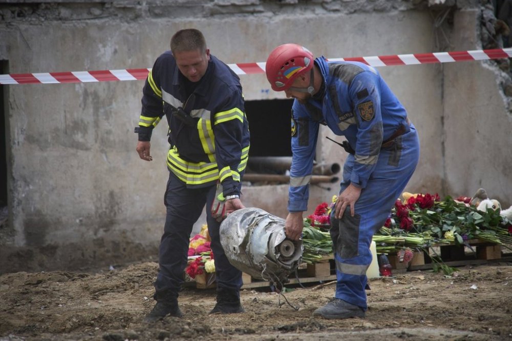 Searchers carry a fragment of the Russian missile that hit a multistory residential house on Thursday evening, in Kyiv, Ukraine, Friday, Aug. 1, 2025. (AP Photo/Efrem Lukatsky)