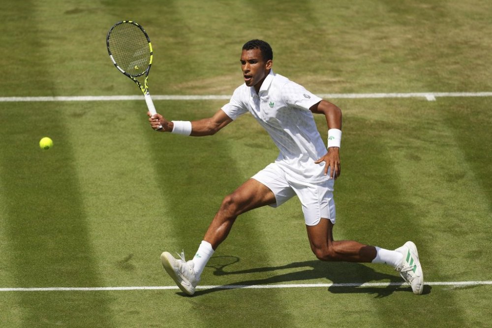 Felix Auger‑Aliassime of Canada returns the ball to Jan-Lennard Struff of Germany during their second round men's singles match at the Wimbledon Tennis Championships in London, Thursday, July 3, 2025. (AP Photo/Kirsty Wigglesworth)