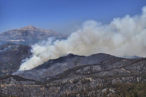 Smoke rises from a wildfire in the town of Rabia, in Syria's Latakia countryside, Saturday, July 12, 2025. (AP Photo/Ghaith Alsayed)