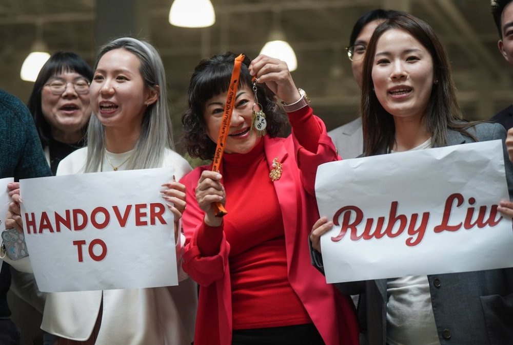 Billionaire Ruby Liu, centre, poses with her staff while holding a set of keys to a former Hudson's Bay-owned Saks Off 5th department store during a