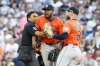 Home plate umpire Gerry Davis, left, and Houston Astros first baseman Christian Walker (8) restrain Astros pitcher Hector Neris, center, at the end of the seventh inning of a baseball game against the Boston Red Sox, Saturday, Aug. 2, 2025, in Boston. (AP Photo/Greg M. Cooper)