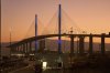 Trucks transporting containers undergo X-ray scanning at entry gates at the Long Beach Container Terminal (LBCT), one of the most advanced, fully automated container terminals in the U.S., with the the Long Beach International Gateway Bridge in the background at the Port of Long Beach, Calif., Thursday, July 31, 2025. (AP Photo/Damian Dovarganes)