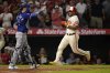 Los Angeles Angels' Yoan Moncada, right, scores on a double by Zach Neto as Texas Rangers catcher Kyle Higashioka gestures during the sixth inning of a baseball game Tuesday, July 29, 2025, in Anaheim, Calif. (AP Photo/Mark J. Terrill)