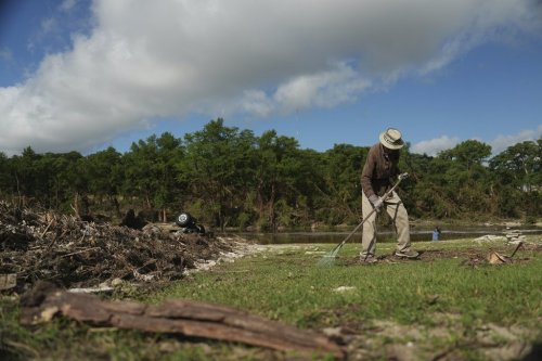 Charles Hanson, 91, cleans up flood debris, Tuesday, July 8, 2025, at Guadelupe Park in Kerrville, Texas. (AP Photo/Joshua A. Bickel)