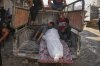 Palestinians mourn around the body of a man killed while trying to reach aid trucks entering northern Gaza through the Zikim crossing with Israel, at Shifa Hospital in Gaza City, Thursday, July 31, 2025. (AP Photo/Jehad Alshrafi)