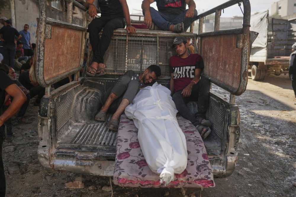 Palestinians mourn around the body of a man killed while trying to reach aid trucks entering northern Gaza through the Zikim crossing with Israel, at Shifa Hospital in Gaza City, Thursday, July 31, 2025. (AP Photo/Jehad Alshrafi)