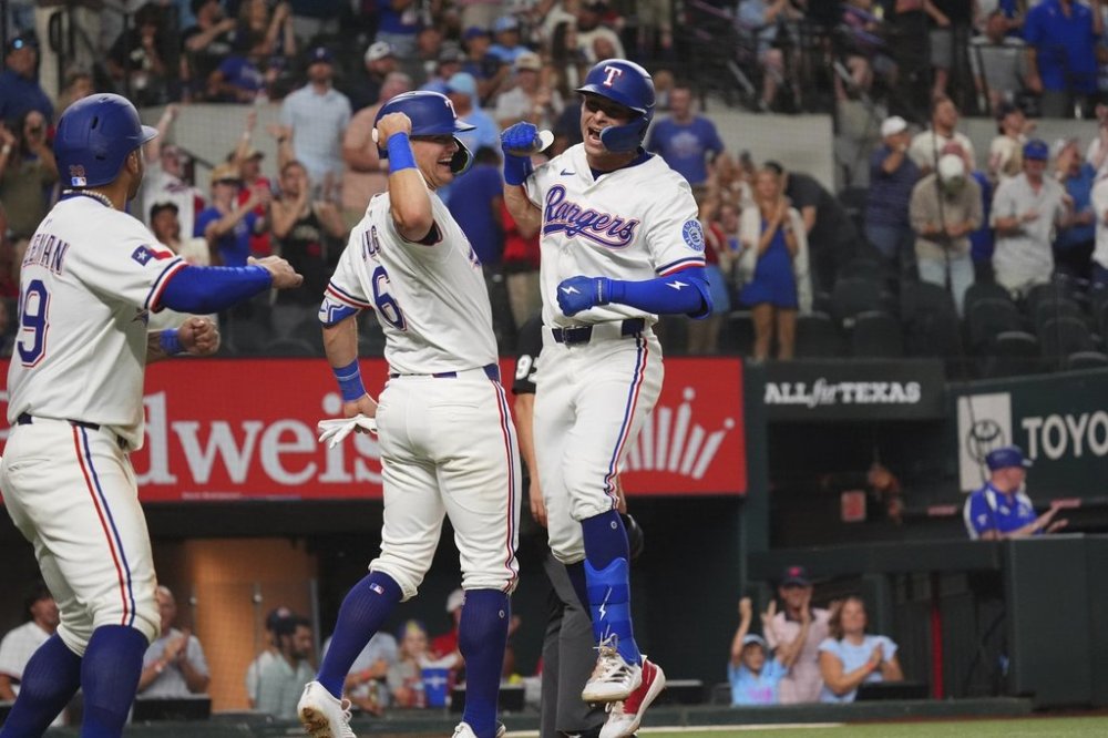 Texas Rangers' Michael Helman, right, celebrates after hitting a home run that also scored teammates Jush Jung (6) and Cody Freeman, left, during the fifth inning of a baseball game against the Athletics, Monday, July 21, 2025, in Arlington, Texas. (AP Photo/LM Otero)