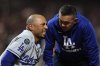 Los Angeles Dodgers' Mookie Betts, left, talks to a trainer after being hit by a pitch during the sixth inning of a baseball game against the San Francisco Giants, Friday, July 11, 2025, in San Francisco. (AP Photo/Godofredo A. Vásquez)