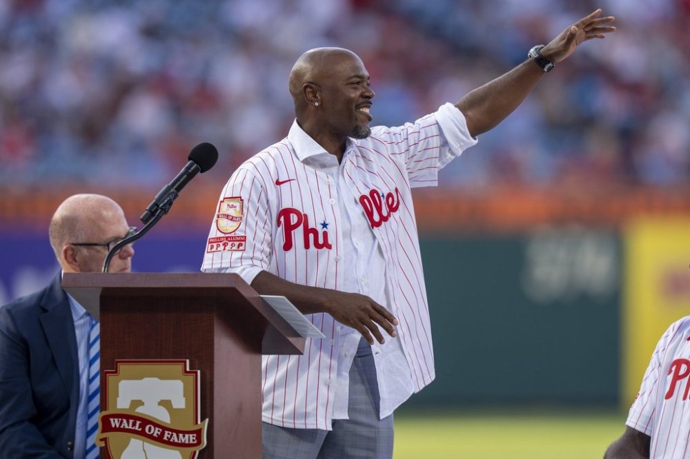 Former Philadelphia Phillies player Jimmy Rollins, center, reacts as he is inducted into the Phillies Wall of Fame prior to a baseball game against the Detroit Tigers, Friday, Aug. 1, 2025, in Philadelphia. (AP Photo/Chris Szagola)