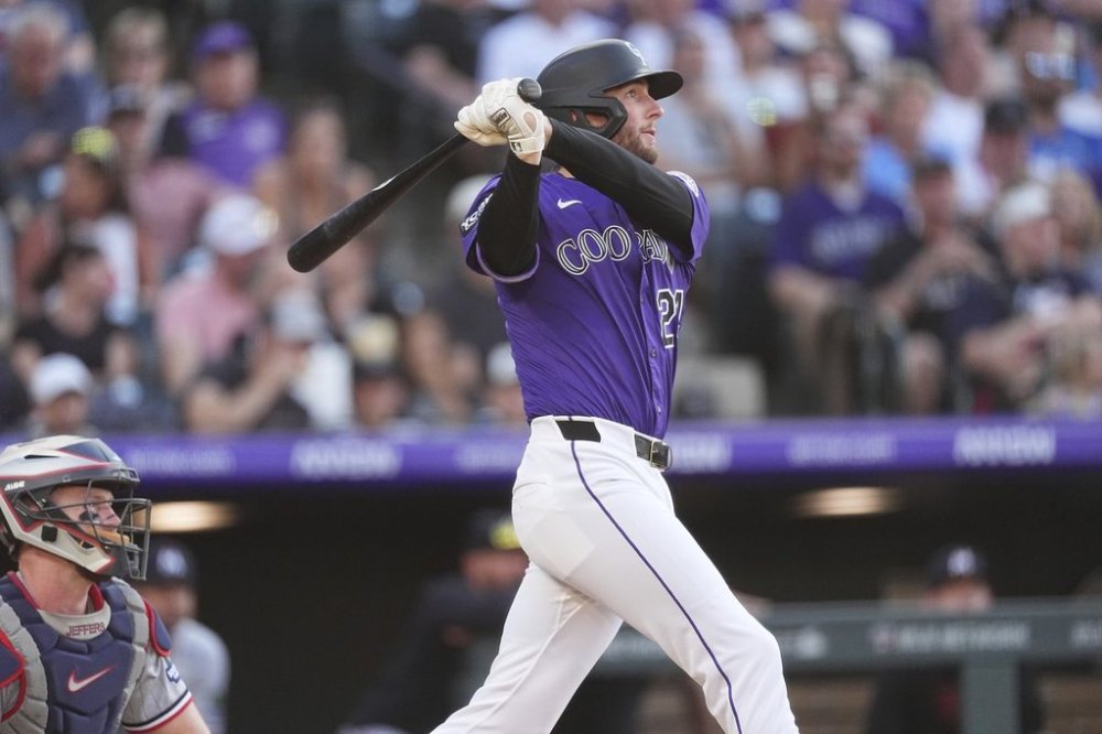 Colorado Rockies' Ryan McMahon follows the flight of his two-run home run off Minnesota Twins starting pitcher Zebby Matthews in the third inning of a baseball game Saturday, July 19, 2025, in Denver. (AP Photo/David Zalubowski)