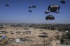 Palestinians rush to collect humanitarian aid airdropped in central Gaza Strip, Thursday, July 31, 2025. (AP Photo/Abdel Kareem Hana)