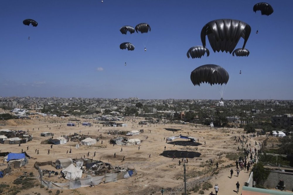 Palestinians rush to collect humanitarian aid airdropped in central Gaza Strip, Thursday, July 31, 2025. (AP Photo/Abdel Kareem Hana)
