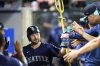 Seattle Mariners' Cal Raleigh is greeted by teammates after hitting a home run during the sixth inning of a baseball game against the Los Angeles Angels, Saturday, July 26, 2025, in Anaheim, Calif. (AP Photo/William Liang)
