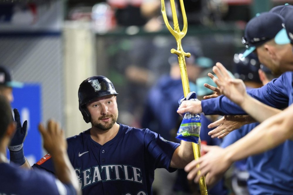 Seattle Mariners' Cal Raleigh is greeted by teammates after hitting a home run during the sixth inning of a baseball game against the Los Angeles Angels, Saturday, July 26, 2025, in Anaheim, Calif. (AP Photo/William Liang)