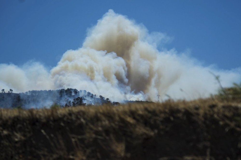 This photo provided by the fire brigade Pompiers13, shows a cloud of smoke over hills near Marseille, southern France, Tuesday, July 8, 2025. (Pompiers13 via AP)