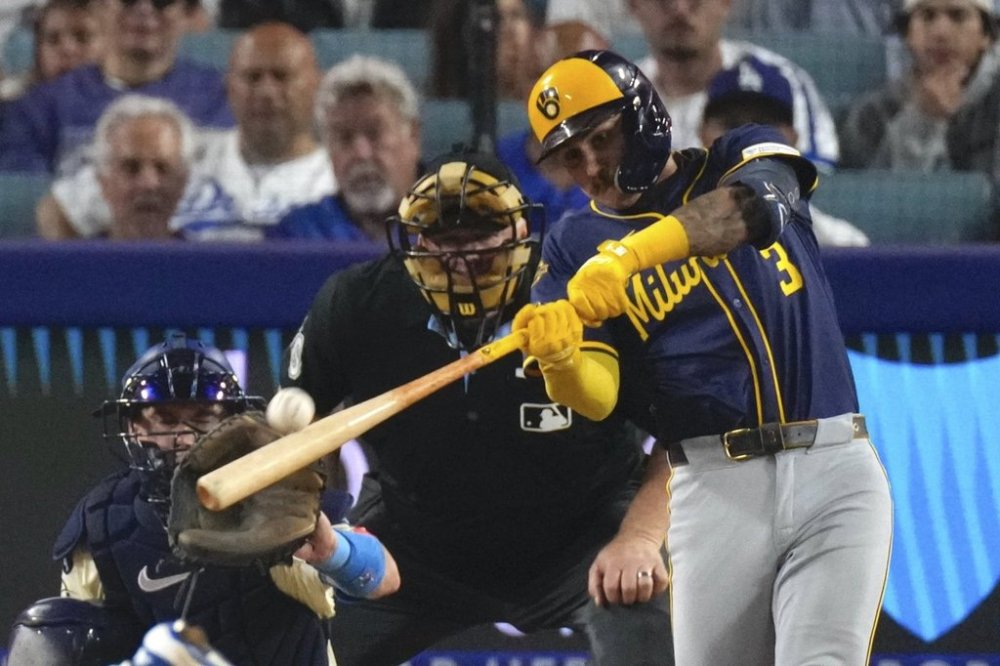 Milwaukee Brewers' Joey Ortiz, right, hits a solo home run as Los Angeles Dodgers catcher Will Smith watches during the eighth inning of a baseball game Saturday, July 19, 2025, in Los Angeles. (AP Photo/Mark J. Terrill)