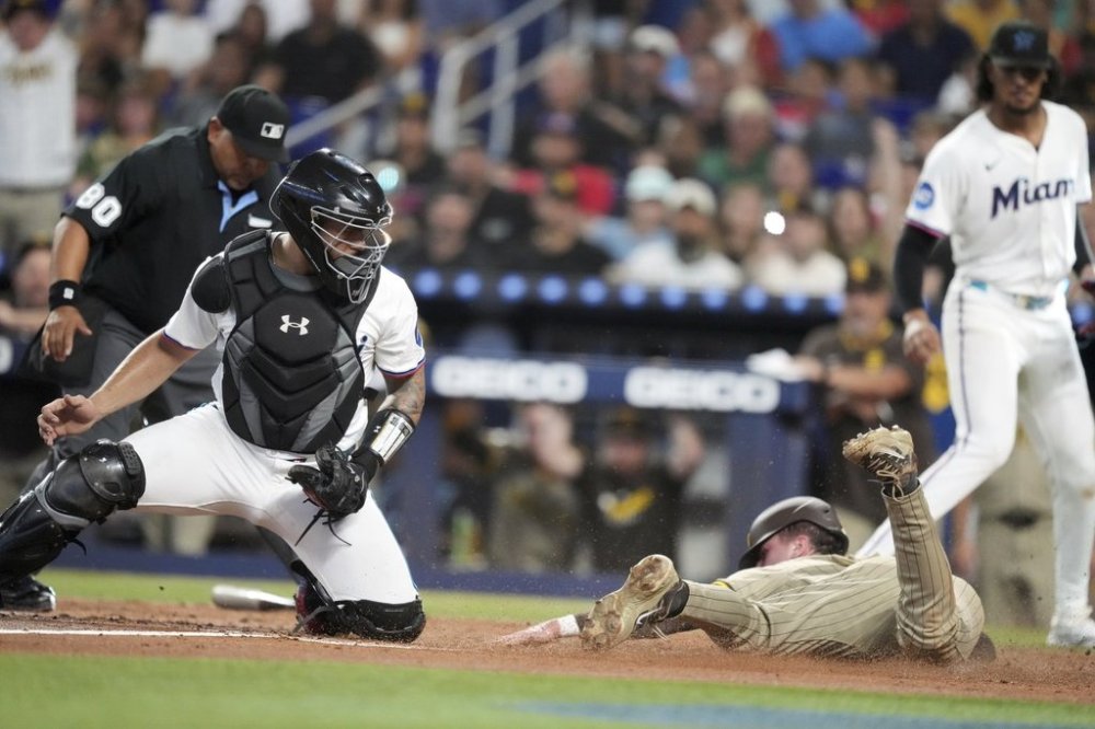 San Diego Padres' Jackson Merrill slides in to home past Miami Marlins catcher Agustín Ramírez to score on a double by San Diego Padres Martín Maldonado, in the second inning of a baseball game, Monday, July 21, 2025, in Miami. (AP Photo/Rebecca Blackwell)