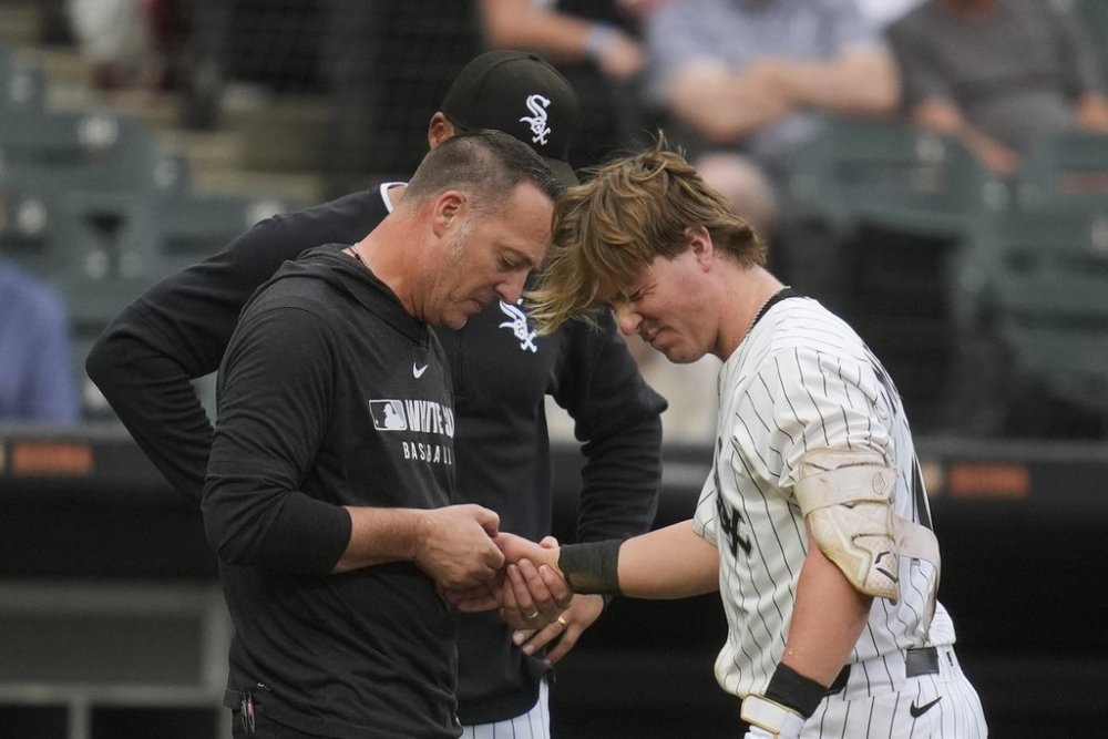 Chicago White Sox's Chase Meidroth (10) is examined after he was hit in the hand with a pitch from Philadelphia Phillies starting pitcher Taijuan Walker (99) during the fifth inning of a baseball game Wednesday, July 30, 2025, in Chicago. (AP Photo/Erin Hooley)