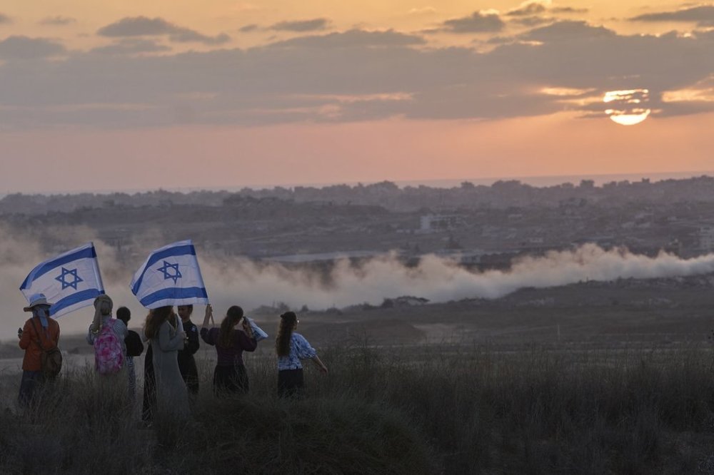 Israeli right-wing activists watch the northern Gaza Strip during a rally calling for the re-establishment of Jewish settlements in the Gaza Strip, near the border in southern Israel, Wednesday, July 30, 2025. (AP Photo/Ohad Zwigenberg)