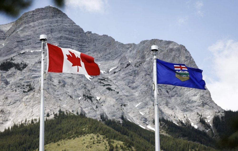 A Canada flag, left, and an Alberta flag flap in the breeze with Mt. Kidd in the background at the site of the G7 Leaders meeting in Kananaskis, Alta., on Monday, June 2, 2025.THE CANADIAN PRESS/Jeff McIntosh
