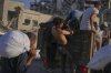 Palestinians climb onto a truck as others carry sacks of flour unloaded from a humanitarian aid convoy bound for Gaza City from the northern Gaza Strip, Thursday, July 31, 2025. (AP Photo/Jehad Alshrafi)