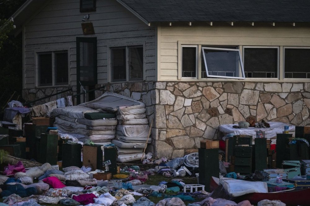 Camper's belongings sit outside one of Camp Mystic's cabins near the Guadalupe River, Monday, July 7, 2025, in Hunt, Texas, after a flash flood swept through the area. (AP Photo/Eli Hartman)